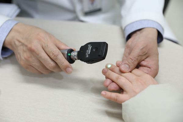 일산백병원 소아청소년과 김영대 교수가 진료 중 아이 손끝을 살펴보고 있다. (사진=일산백병원)